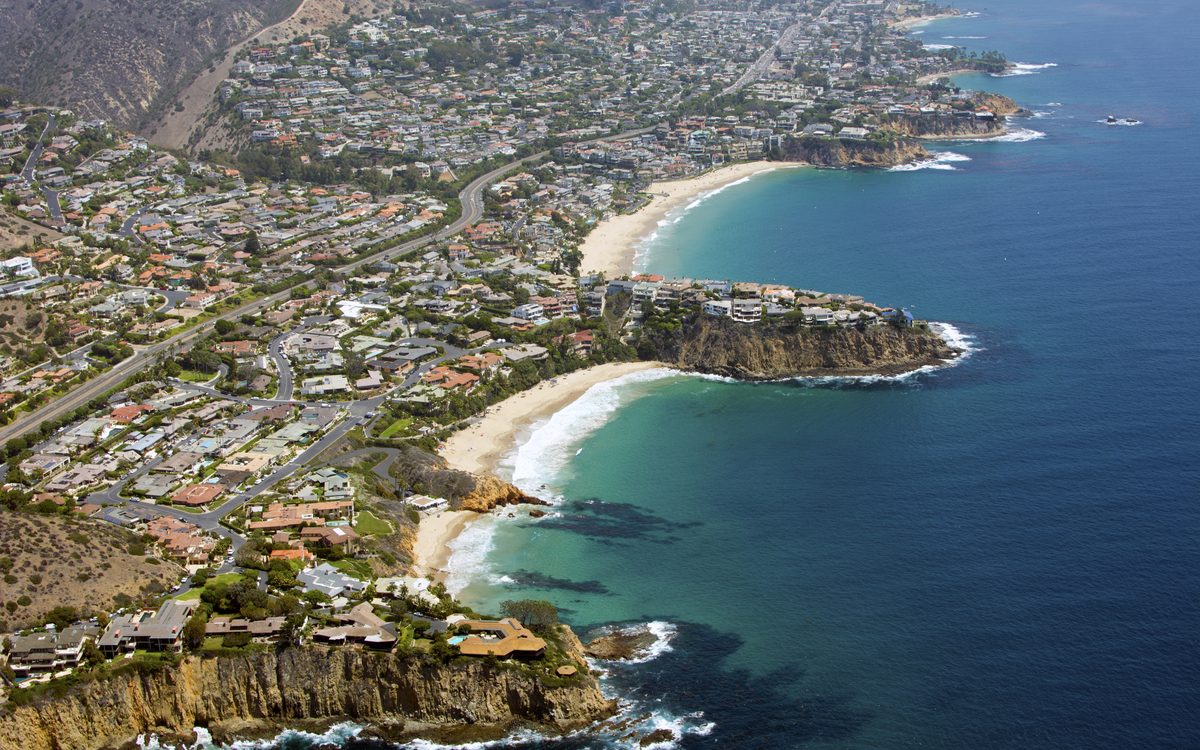Aerial view of the Orange County coastline, with beaches and coves below hillside homes